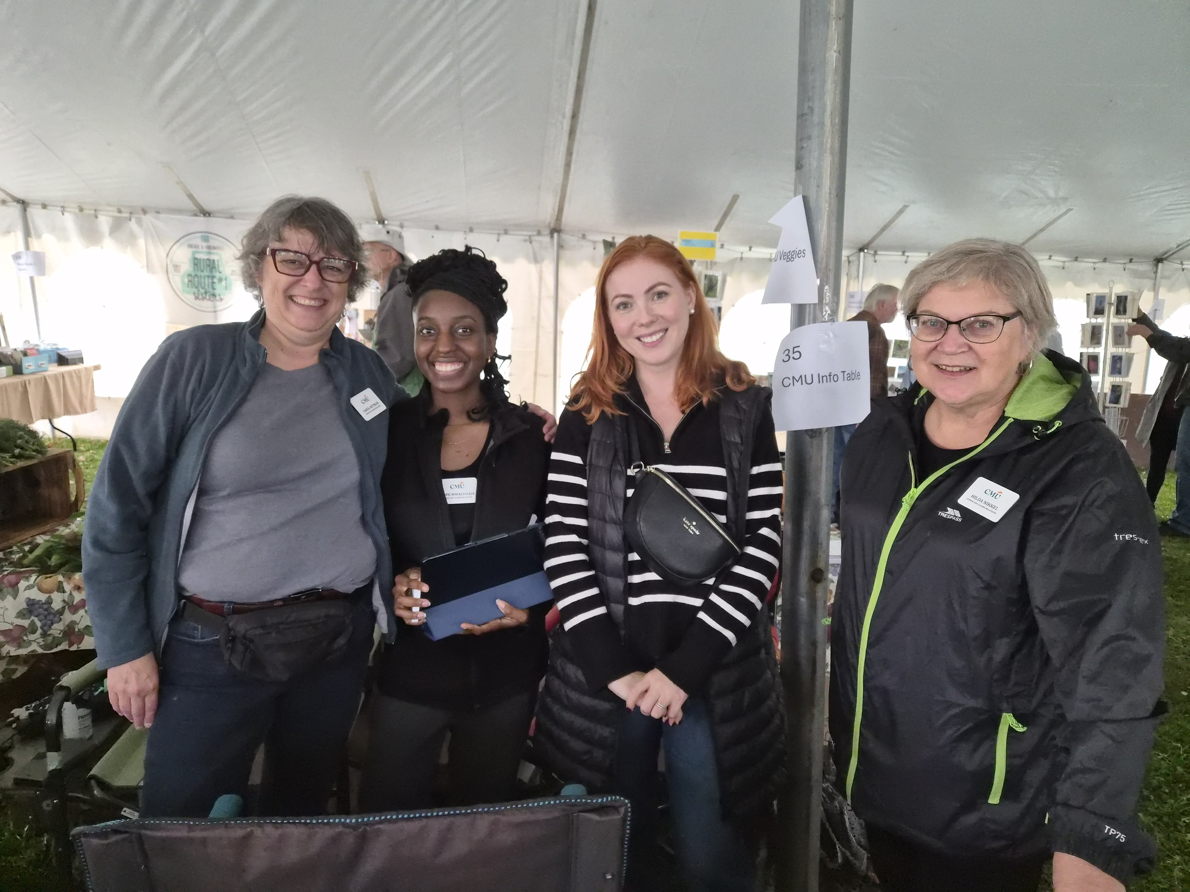 Staff work a table at Fall at CMU farmers' market