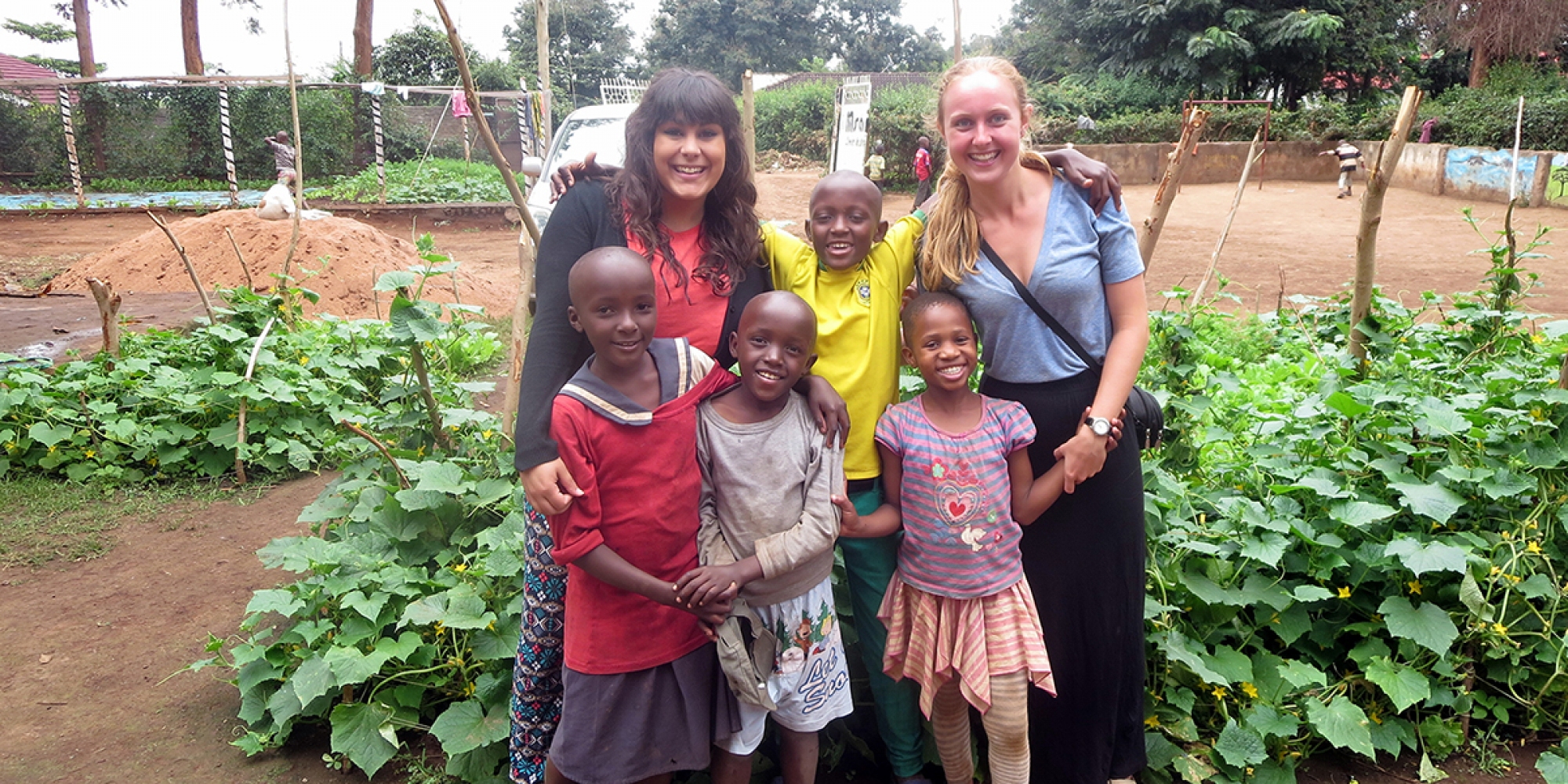 Jenn French (right) stands with fellow volunteer, Karina Rottinger, and some of the children at Msamaria Centre for Street Children in front of the garden they planted to help reduce the food costs of the centre. (Photo courtesy Jenn French)
