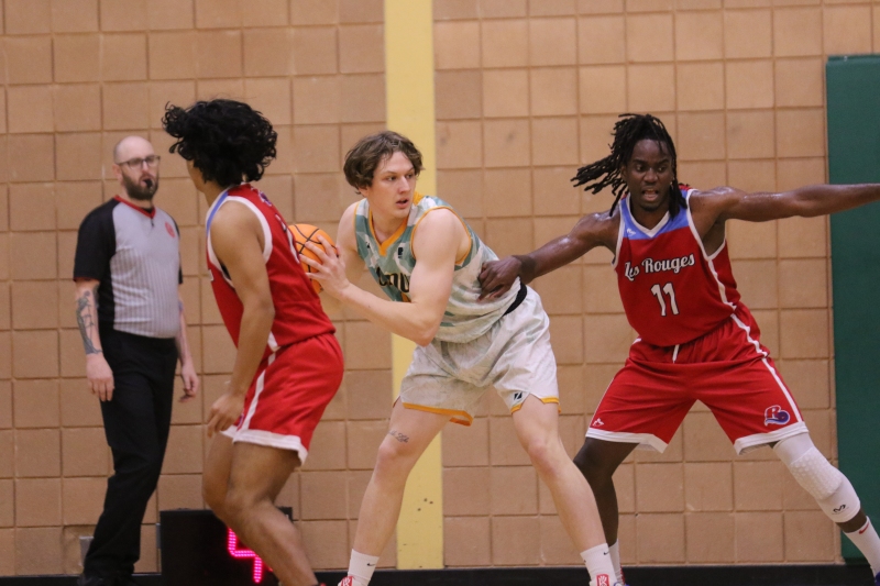 Cameron collects a rebound and looks to score in their MCAC home-opener against Les Rouges