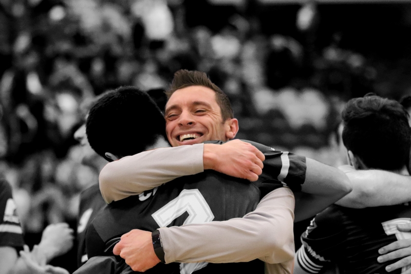 Pereira embraces a team member after winning the 2020 MCAC Futsal Championship