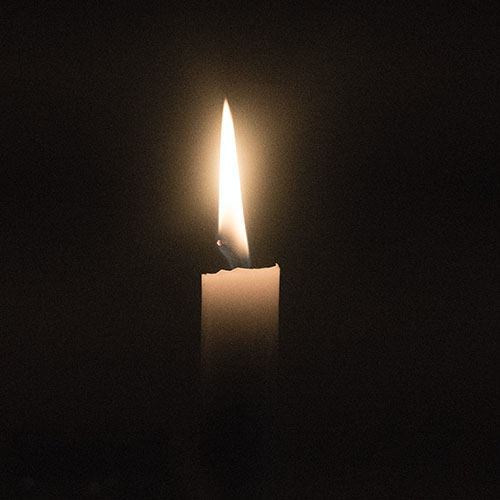 A single candle all alone in a dark room