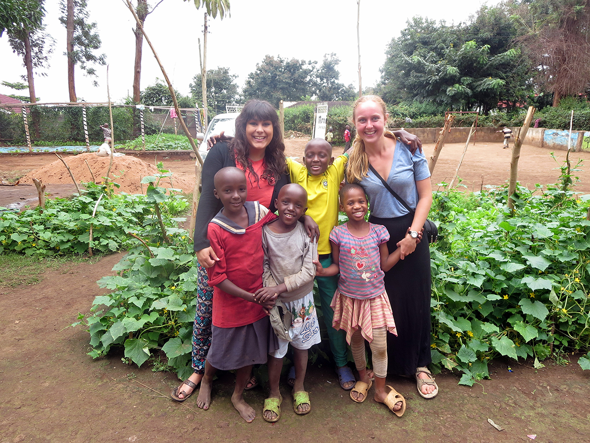 Jenn French (right) stands with fellow volunteer, Karina Rottinger, and some of the children at Msamaria Centre for Street Children in front of the garden they planted to help reduce the food costs of the centre. (Photo courtesy Jenn French)