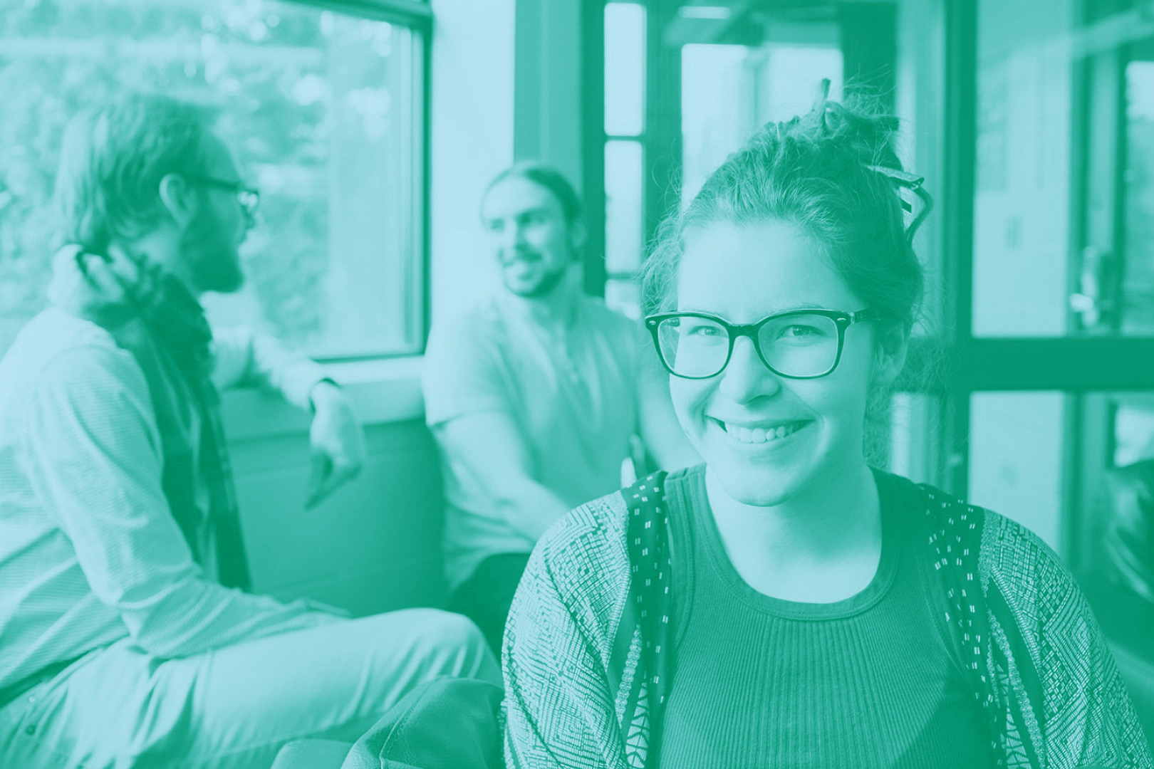 Student facing the camera with other students chatting in the background