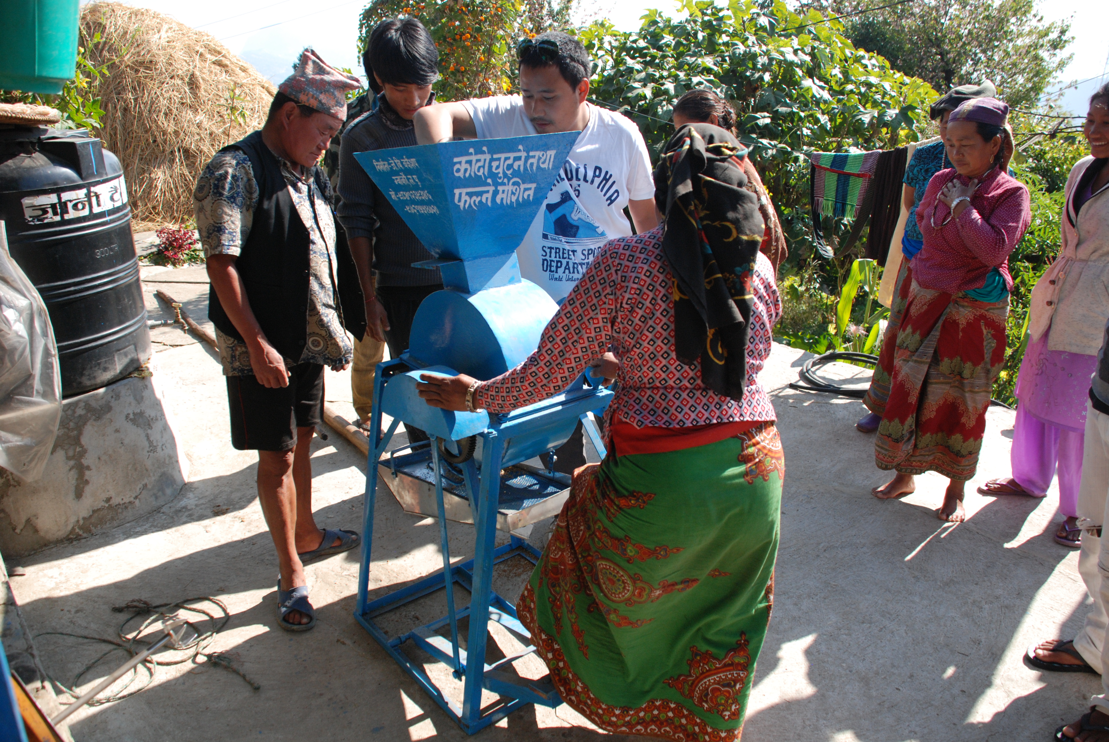 Project participants test a threshing machine (Photo courtesy Kirit Patel)