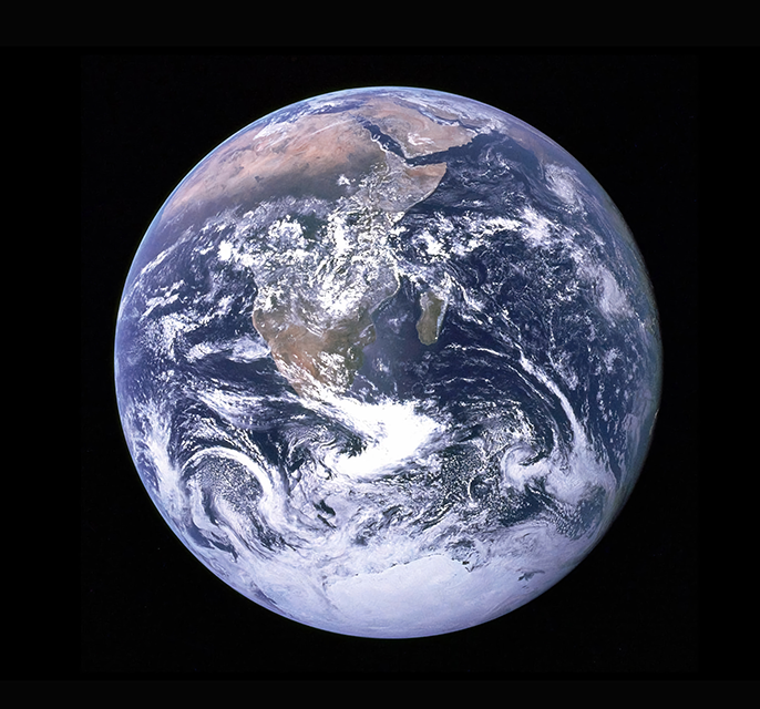 NASA image of the Earth from space, round and green and blue with clouds swirling above