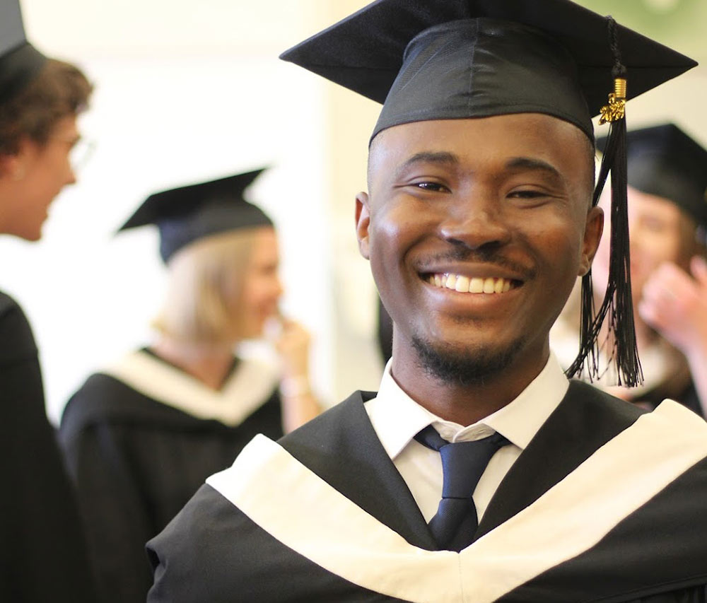 young male graduate student smiling for the camera
