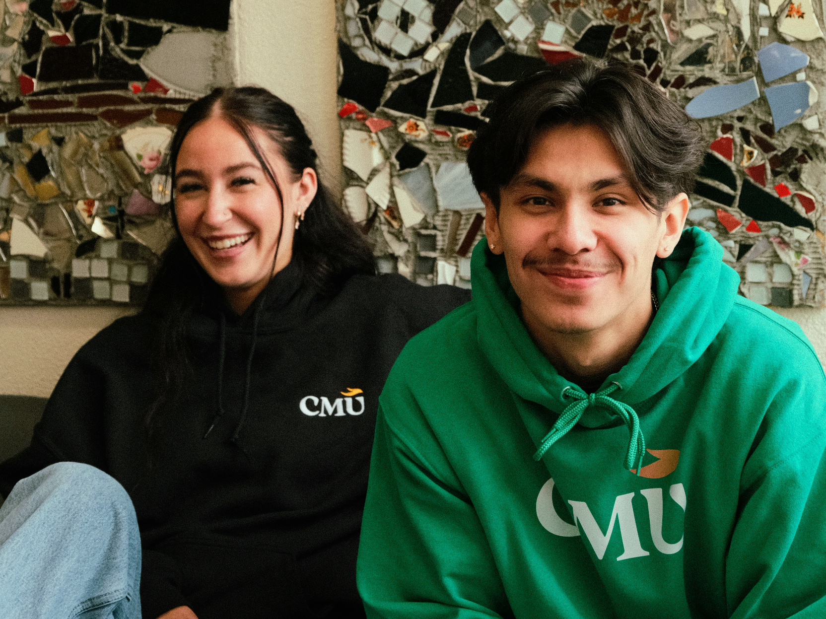 A pair of students smile at the camera while wearing CMU shirts