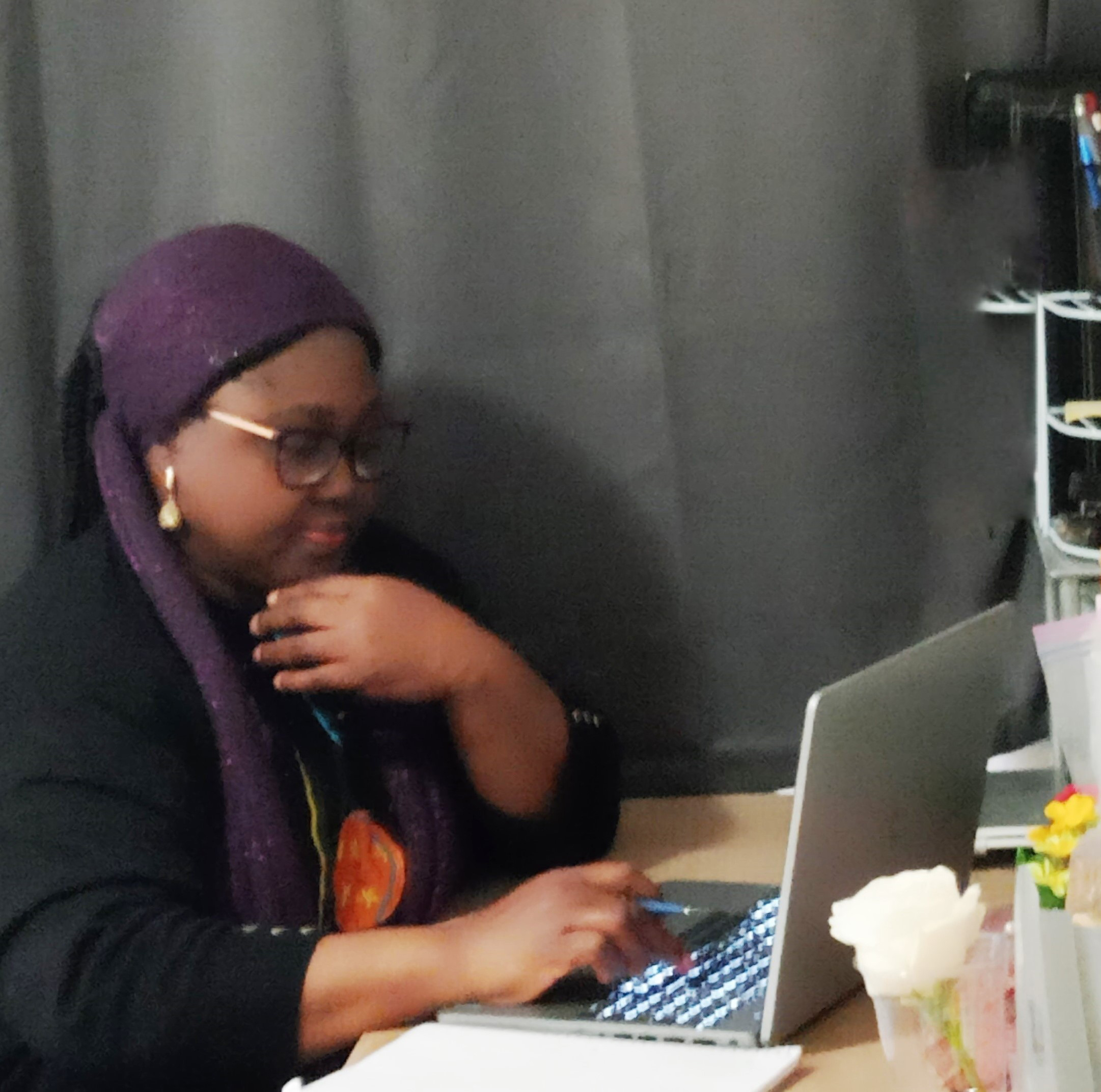 China Iwobi working at a desk with an open laptop.