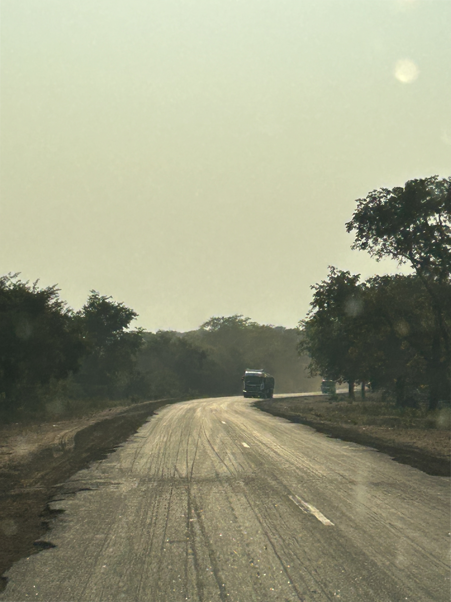 A faraway photo of a truck driving on a road.